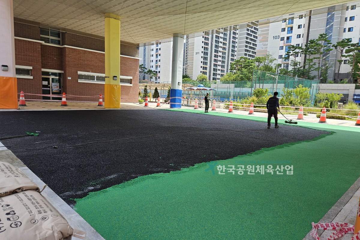 컬러표층 마감 작업 중인 탄성포장재 시공 모습